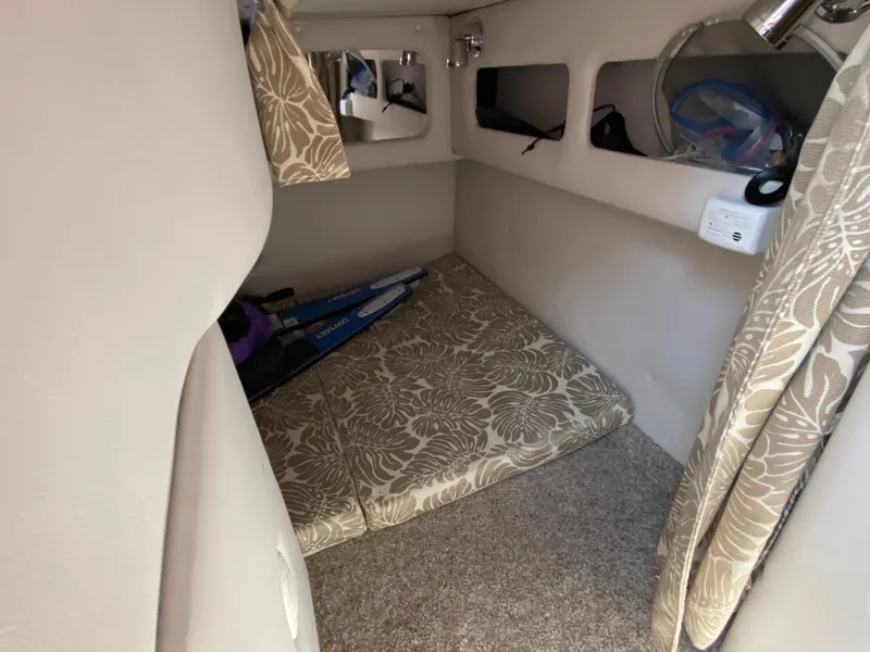 Slide: The Image of 2022 Crownline 264 CR cabin interior with floral cushions and storage compartments. - 19