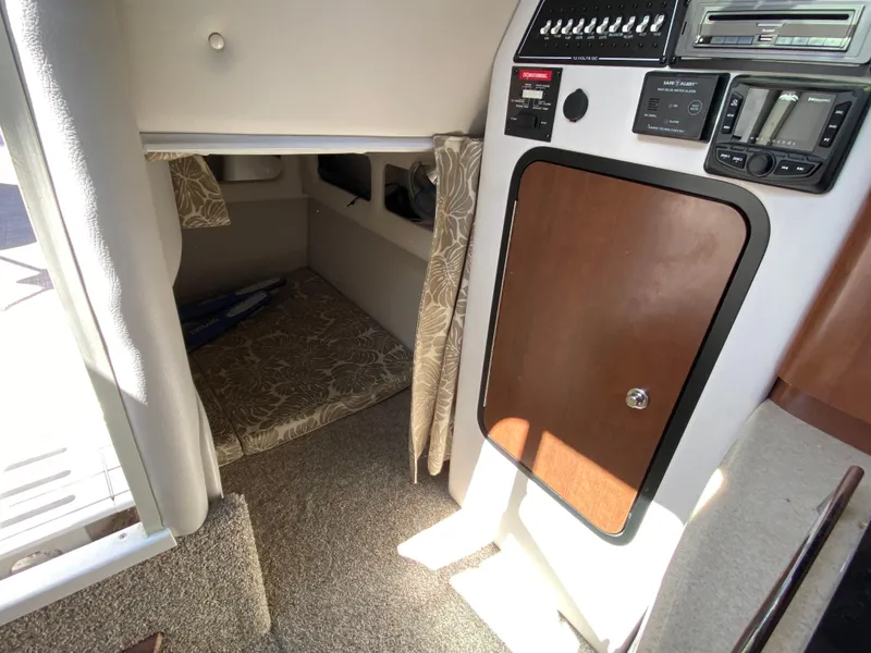 Slide: The Image of 2022 Crownline 264 CR cabin interior with control panel and cozy sleeping area. - 20