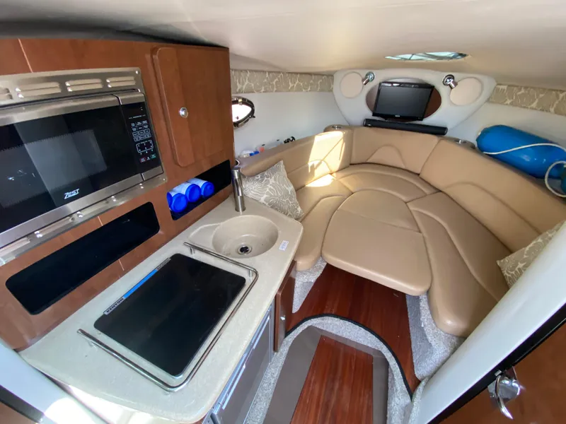 Slide: The Image of Interior of 2022 Crownline 264 CR boat with kitchenette and seating area. - 23