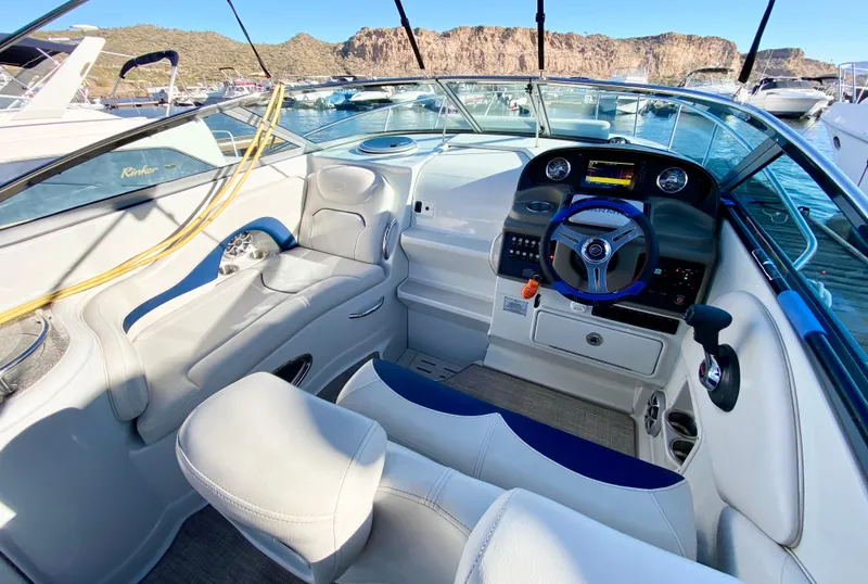 Slide: The Image of 2022 Crownline 264 CR boat interior with modern dashboard and comfortable seating in a marina. - 32