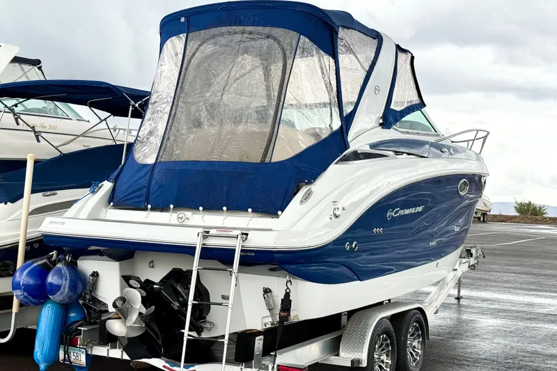 Slide: The Image of 2022 Crownline 264 CR boat with blue canopy on a trailer in a parking lot. - 41