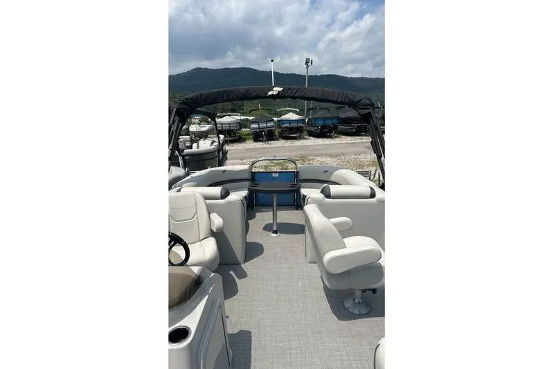 Slide: The Image of 2024 Starcraft EXS 3 boat interior with seating, steering wheel, and canopy, parked outdoors. - 5