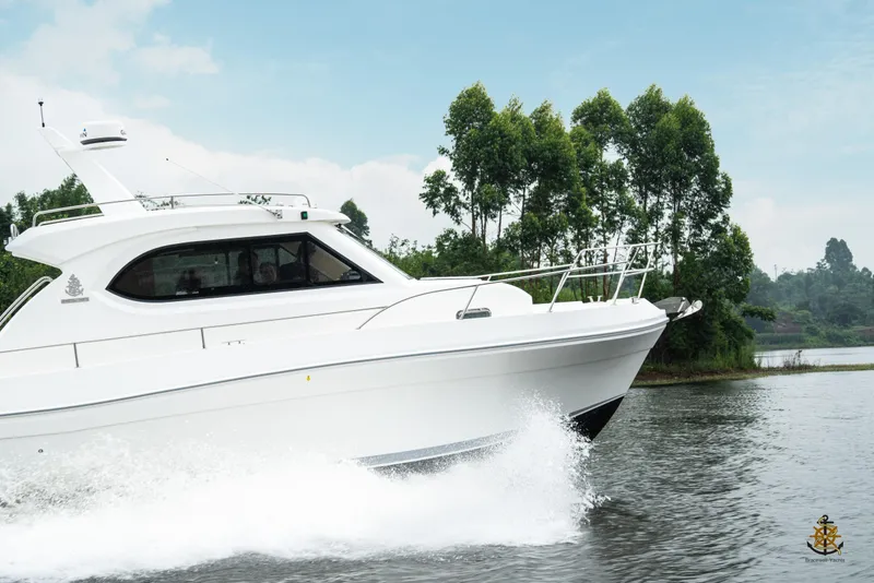 Slide: The Image of 2025 Bracewell Commander 36SF yacht cruising on a serene lake with lush greenery. - 4