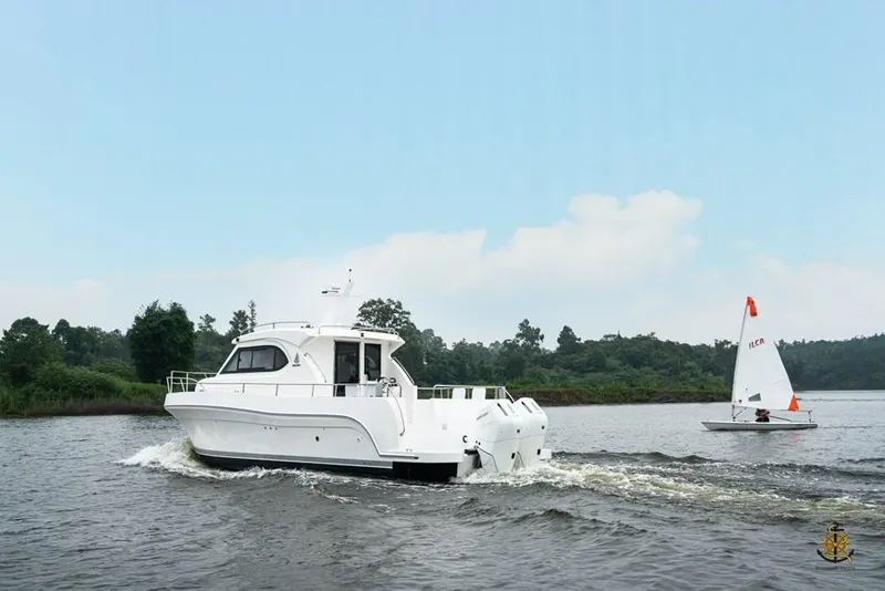 Slide: The Image of 2025 Bracewell Commander 36SF yacht cruising alongside a small sailboat on a calm river. - 5