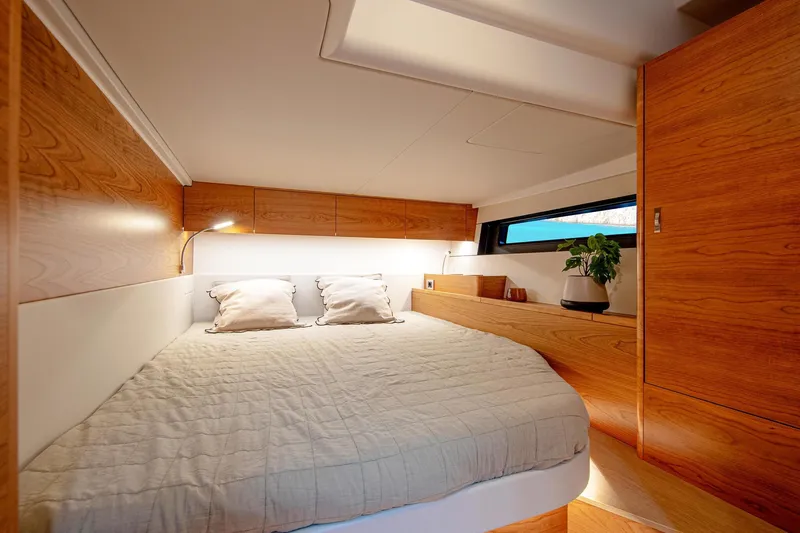 Slide: The Image of Luxurious cabin interior of 2026 Hanse 590 yacht with wooden finishes and cozy bedding. - 14