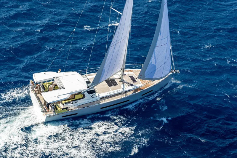 Slide: The Image of 2026 Hanse 590 yacht sailing on open blue ocean waters. - 32