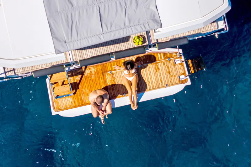 Slide: The Image of Aerial view of a 2026 Hanse 590 yacht with people relaxing on deck. - 24