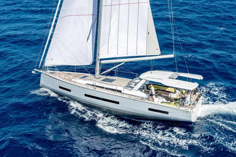 Slide: The Image of 2026 Hanse 590 yacht sailing on open blue sea with white sails. - 34