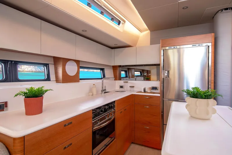 Slide: The Image of Luxurious 2026 Hanse 590 yacht kitchen with modern design, stainless steel appliances, and elegant wood cabinetry. - 9