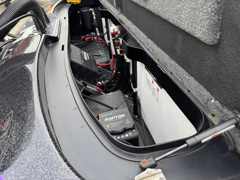 Slide: The Image of 2024 Skeeter FXR20 Limited Bass boat battery compartment with Raptor charger and wiring. - 5