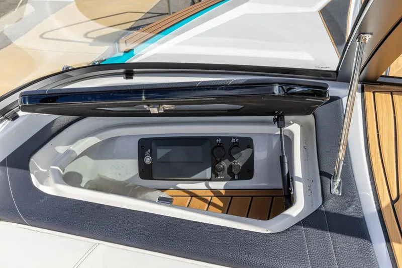 Slide: The Image of 2023 Nautique Ski Nautique boat dashboard with open storage compartment and control panel. - 19