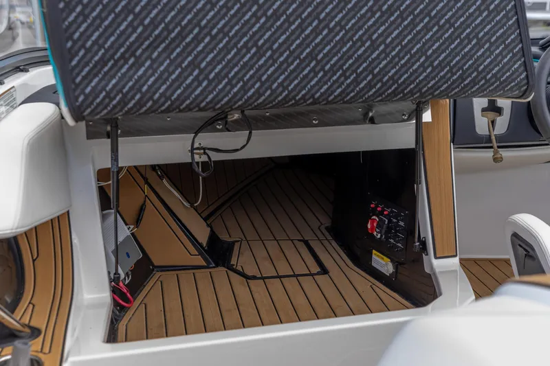 Slide: The Image of 2023 Nautique Ski Nautique interior with open storage compartment and wooden flooring. - 21
