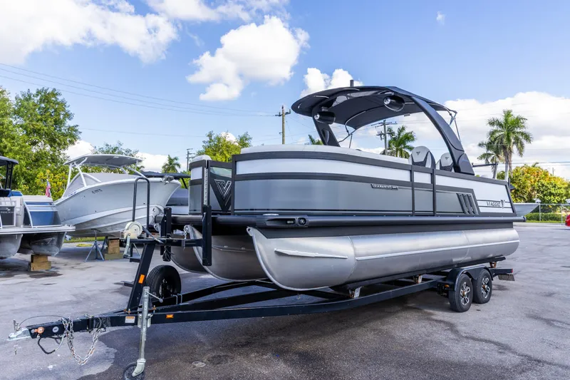 Slide: The Image of 2026 Viaggio Diamante Q pontoon boat on trailer, parked outdoors under blue sky. - 10