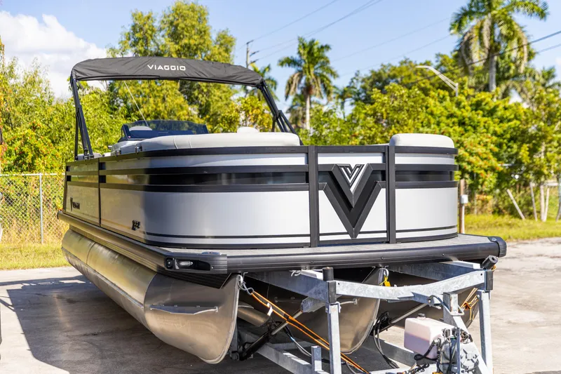 Slide: The Image of 2026 Viaggio Lago X-U pontoon boat on trailer, surrounded by lush greenery. - 9
