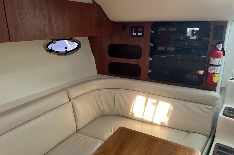 Slide: The Image of 1995 Tiara Yachts 3100 Open interior with beige seating and control panel. - 17