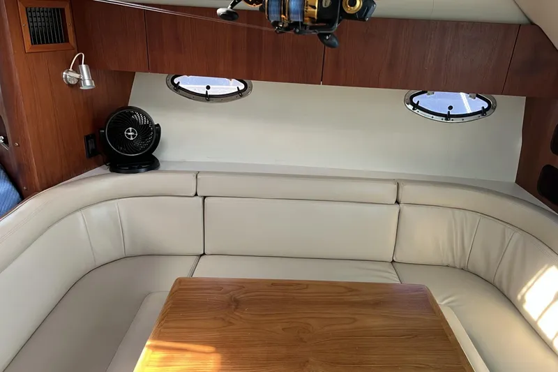 Slide: The Image of Interior of 1995 Tiara Yachts 3100 Open with white seating and wooden table. - 18