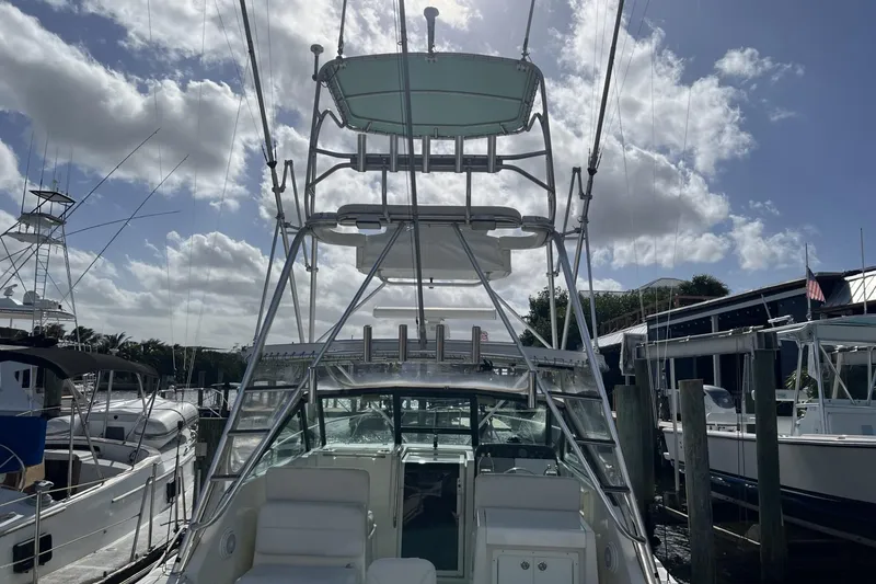 Slide: The Image of 1995 Tiara Yachts 3100 Open at marina, featuring tower and clear sky. - 3