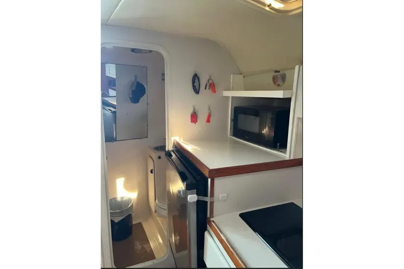 Slide: The Image of 1995 Tiara Yachts 3100 Open interior with kitchenette and compact bathroom. - 8