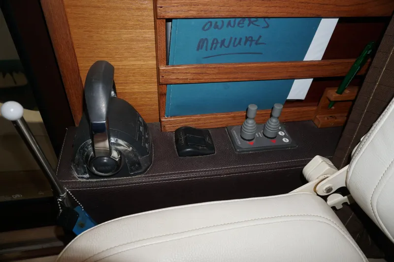 Slide: The Image of 2013 Ranger Tugs S-31 helm controls with owner's manual in wooden holder. - 22