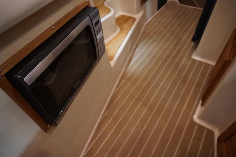 Slide: The Image of Interior of 2013 Ranger Tugs S-31 with microwave and wooden steps. - 33