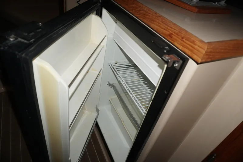 Slide: The Image of Open refrigerator inside 2013 Ranger Tugs S-31 boat, showcasing interior shelves. - 36