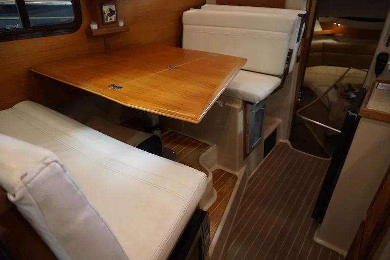 Slide: The Image of 2013 Ranger Tugs S-31 interior with wooden table and cushioned seating. - 39
