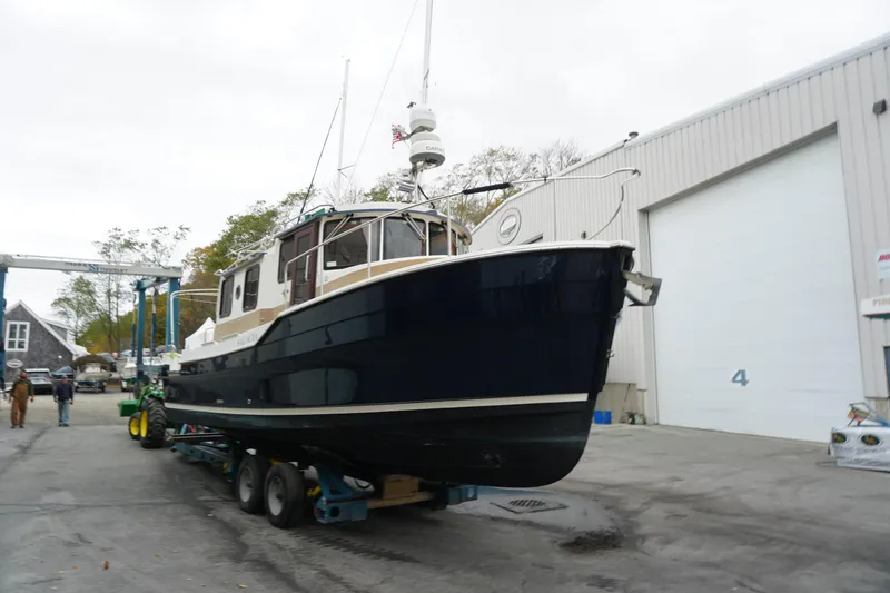 Slide: The Image of 2013 Ranger Tugs S-31 boat on trailer outside a large garage. - 4