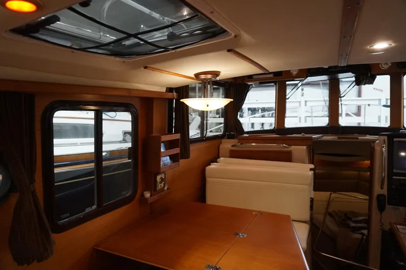 Slide: The Image of Interior of 2013 Ranger Tugs S-31 boat, featuring wood finishes and seating area. - 40