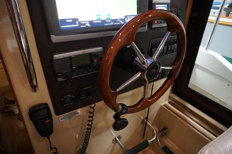 Slide: The Image of 2013 Ranger Tugs S-31 helm with wooden steering wheel and navigation equipment. - 42