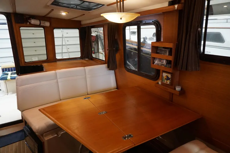 Slide: The Image of Interior of 2013 Ranger Tugs S-31 with wooden table and white seating. - 45