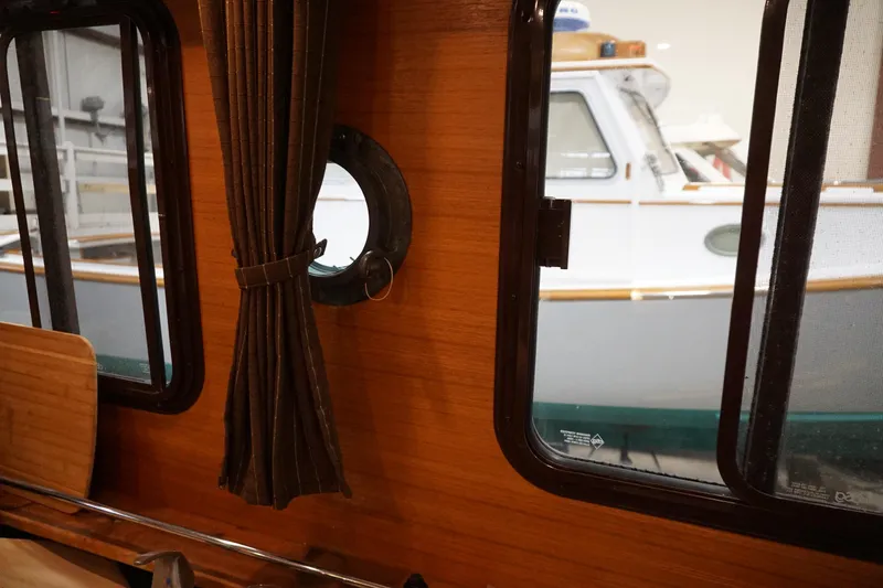 Slide: The Image of Interior view of 2013 Ranger Tugs S-31, showcasing wooden paneling and window. - 52