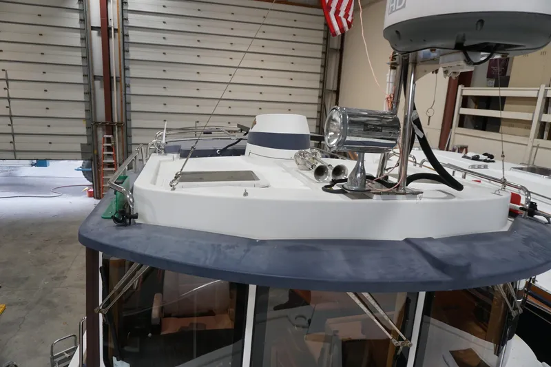 Slide: The Image of 2013 Ranger Tugs S-31 boat in a garage, featuring radar and spotlight equipment. - 62