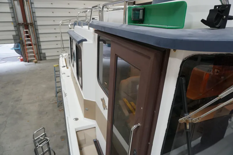 Slide: The Image of 2013 Ranger Tugs S-31 boat in a garage, side view with green navigation light. - 63