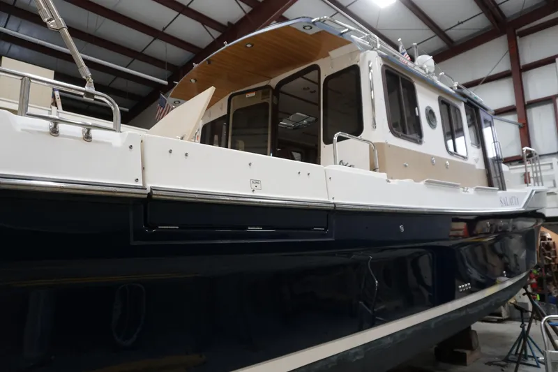 Slide: The Image of 2013 Ranger Tugs S-31 boat in a warehouse, showcasing its sleek design and structure. - 7