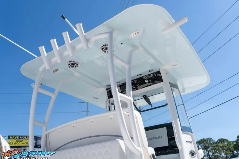 Slide: The Image of 2026 Sea Hunt Ultra 285 SE boat with T-top and rod holders under clear blue sky. - 22