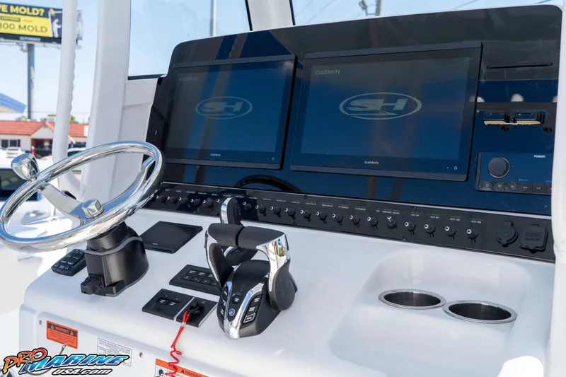 Slide: The Image of 2026 Sea Hunt Ultra 285 SE boat dashboard with Garmin displays and steering wheel. - 27