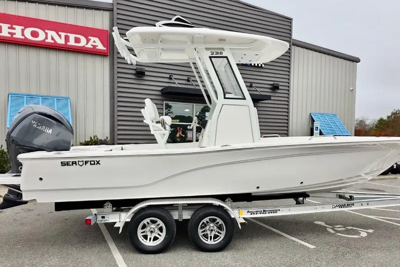 Slide: The Image of 2026 Sea Fox 231 Bay Fox boat on trailer outside Honda dealership. - 14
