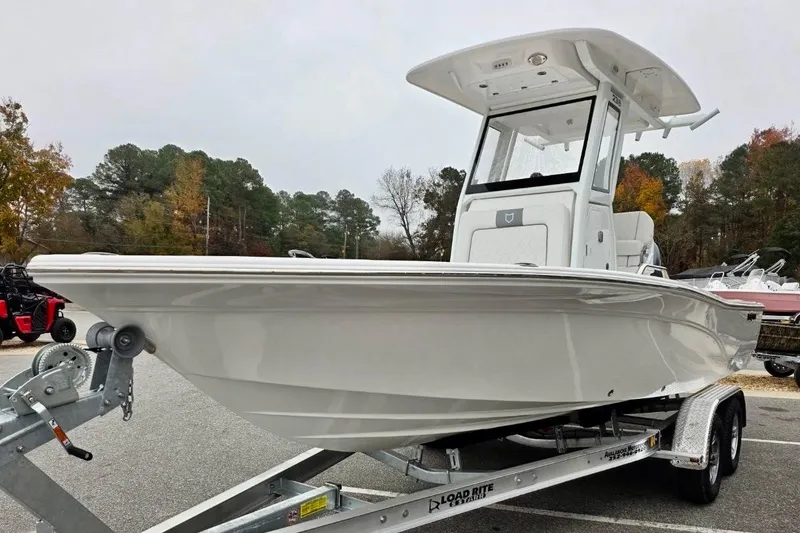Slide: The Image of 2026 Sea Fox 231 Bay Fox boat on trailer, parked outdoors with trees in background. - 19