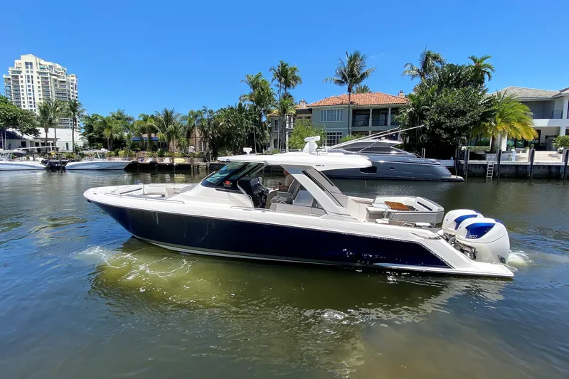 The Image of 2019 Tiara Sport 38 LS boat on a sunny waterfront with palm trees. - 0