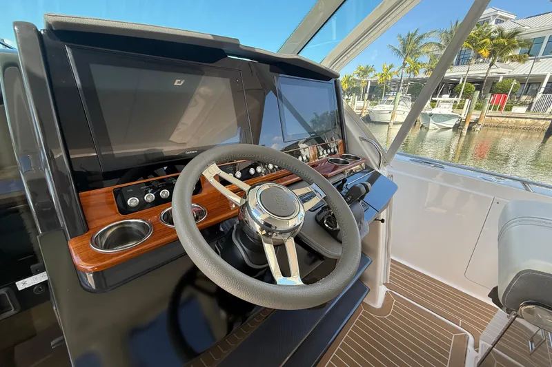 Slide: The Image of 2019 Tiara Sport 38 LS helm with modern controls and dual displays, dockside view. - 12