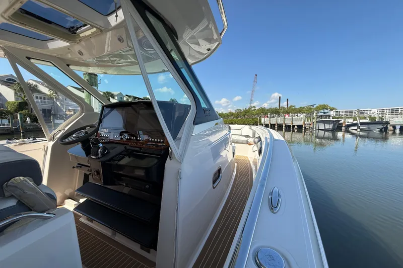 Slide: The Image of 2019 Tiara Sport 38 LS boat docked, showcasing helm and sleek design. - 13