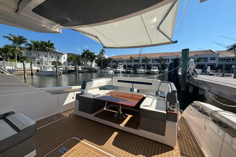 Slide: The Image of 2019 Tiara Sport 38 LS yacht interior with seating and table, docked in a marina. - 19