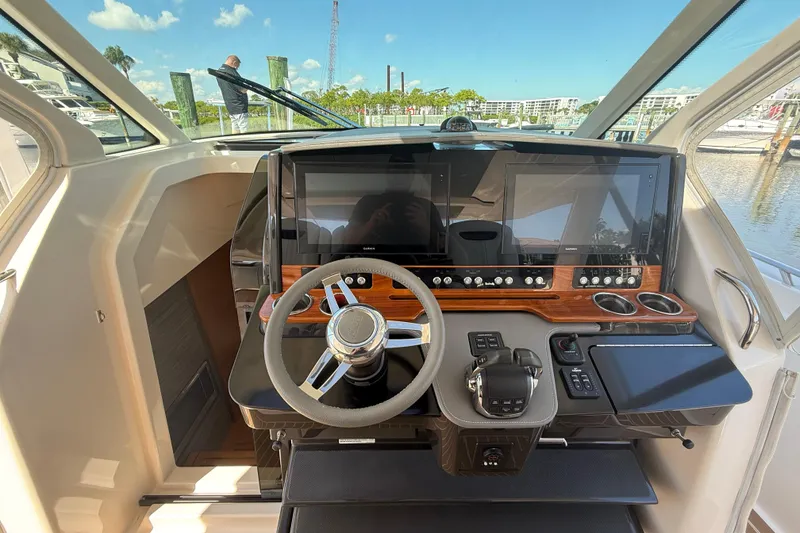 Slide: The Image of 2019 Tiara Sport 38 LS helm with modern controls and dual displays, dockside view. - 8