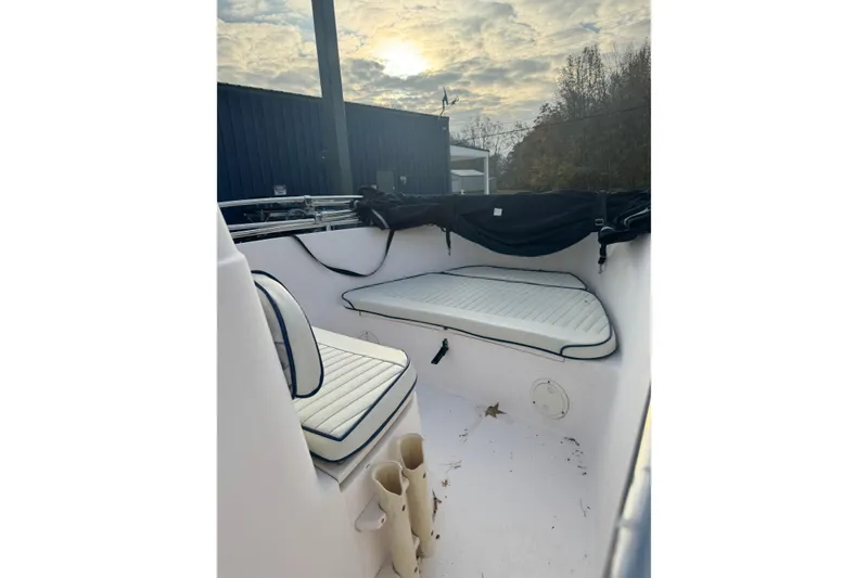 Slide: The Image of 2006 Grady-White Sportsman 180 boat interior with cushioned seating under a cloudy sky. - 9