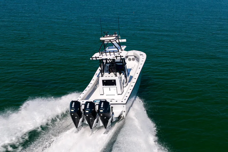 Slide: The Image of 2025 Conch 33 boat cruising on open water with triple outboard engines. - 20