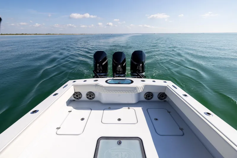 Slide: The Image of 2025 Conch 33 boat with triple outboard motors cruising on open water. - 32