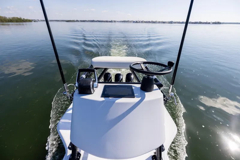 Slide: The Image of 2025 Conch 33 boat steering console on calm water, showcasing modern design and technology. - 59