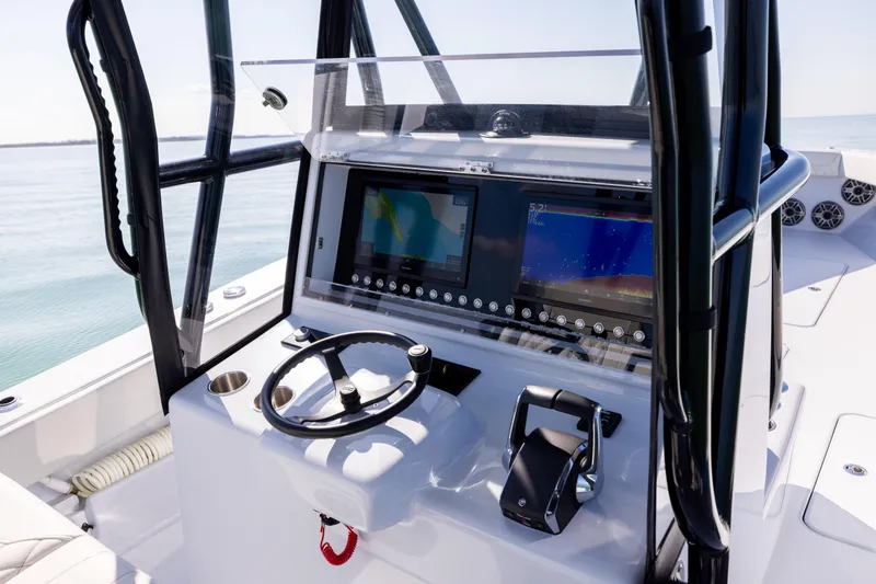 Slide: The Image of 2025 Conch 33 boat dashboard with modern navigation screens and steering wheel. - 68