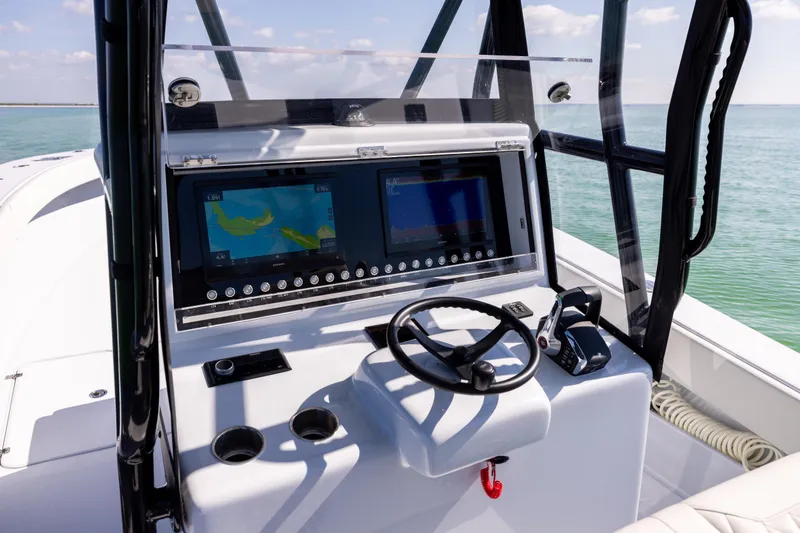 Slide: The Image of 2025 Conch 33 boat dashboard with dual navigation screens and steering wheel. - 69