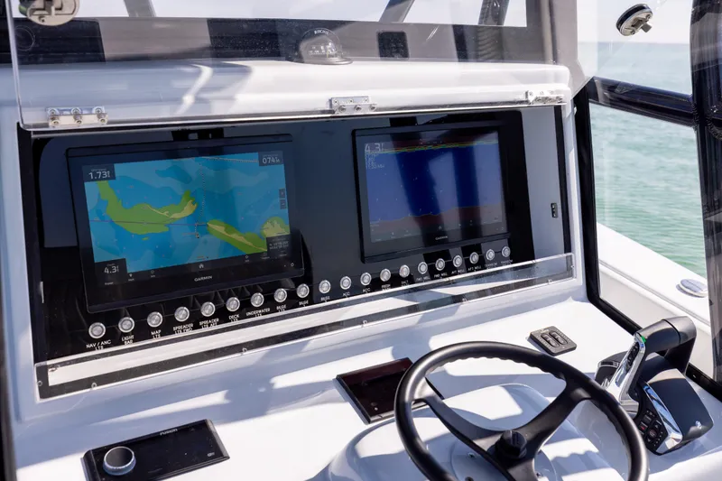Slide: The Image of Control panel of 2025 Conch 33 boat with navigation screens and steering wheel. - 70